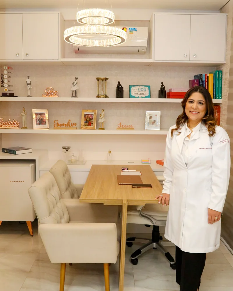 Dra. Vívian Costa de jaleco na sala de consulta